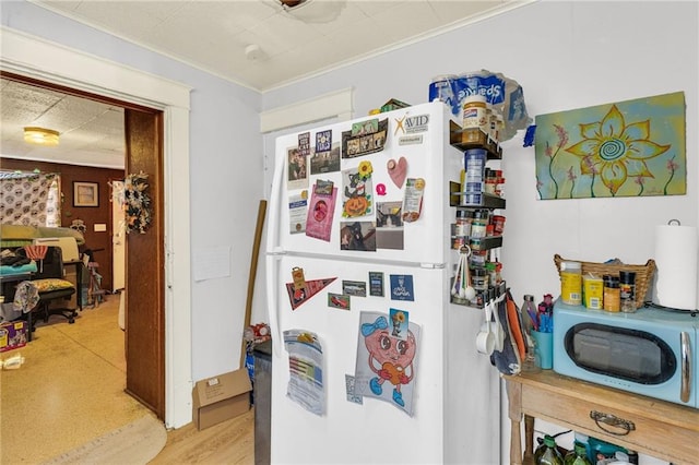 kitchen featuring ornamental molding and freestanding refrigerator