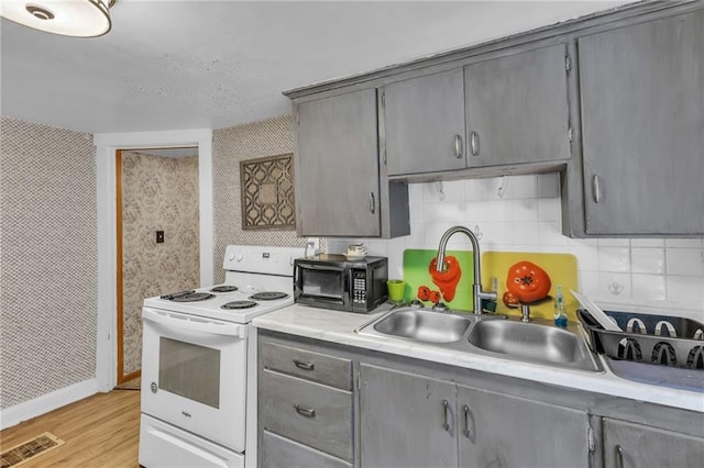 kitchen with black microwave, light countertops, electric range, and gray cabinetry