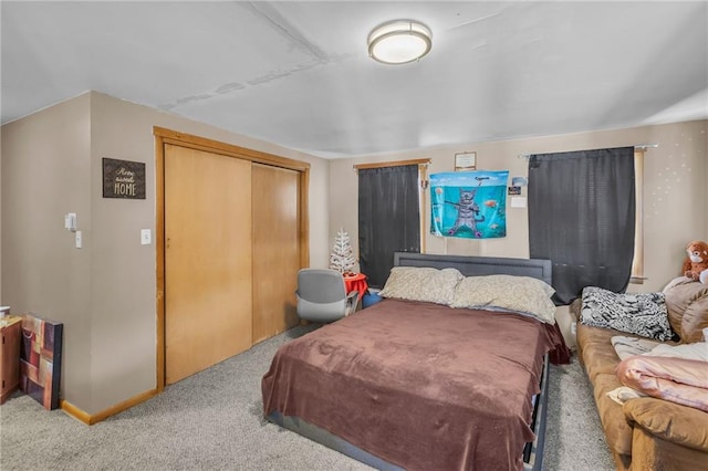 bedroom featuring light carpet, a closet, and baseboards