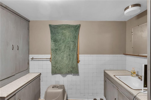 bathroom with wainscoting, tile walls, and vanity