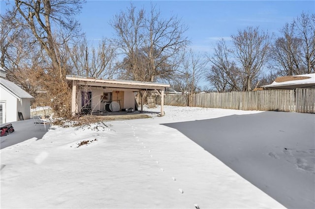 yard layered in snow featuring fence