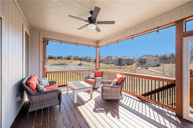 deck with a residential view, outdoor lounge area, a ceiling fan, and a water view