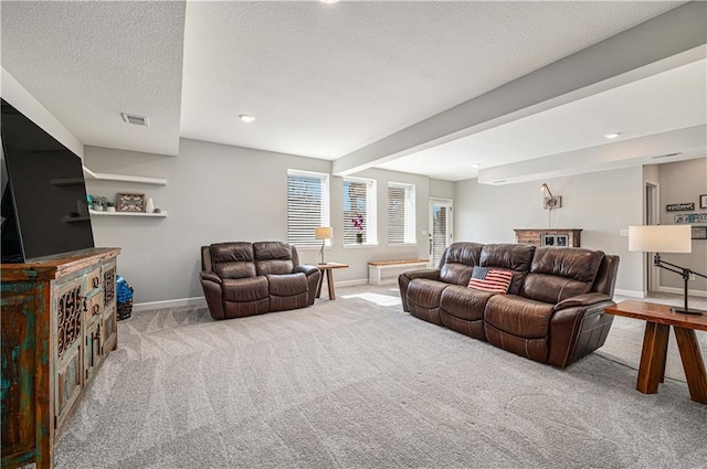 carpeted living area with beam ceiling, visible vents, a textured ceiling, and baseboards