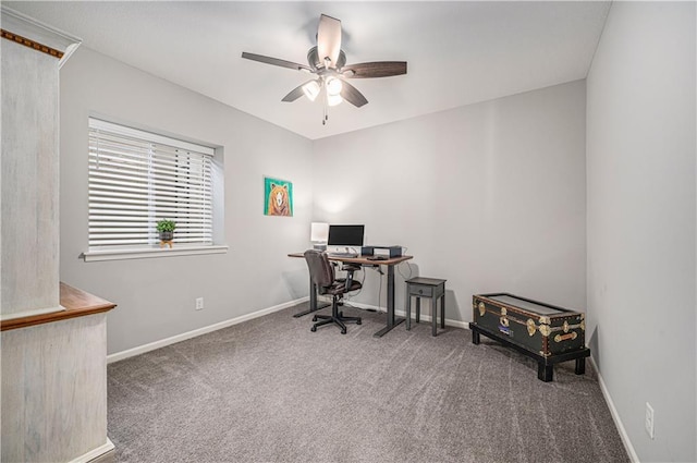 carpeted office space with baseboards and a ceiling fan