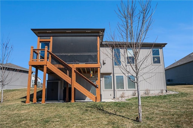 back of property featuring stairs, a yard, and a sunroom