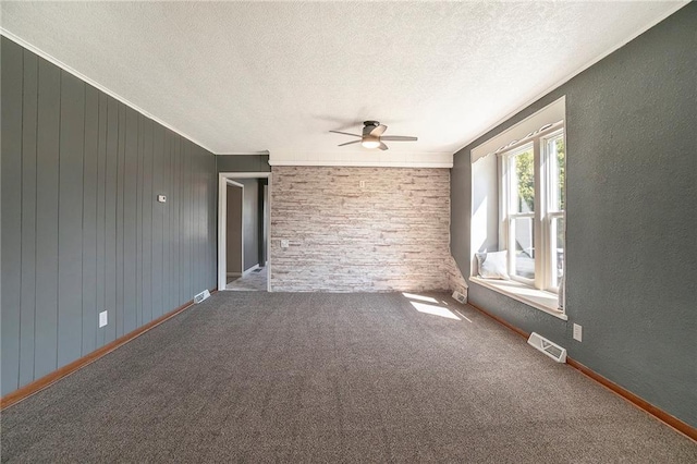 spare room featuring ceiling fan, crown molding, a textured ceiling, and carpet