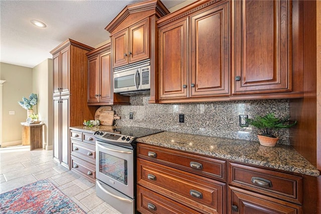 kitchen with backsplash, stainless steel appliances, and dark stone counters