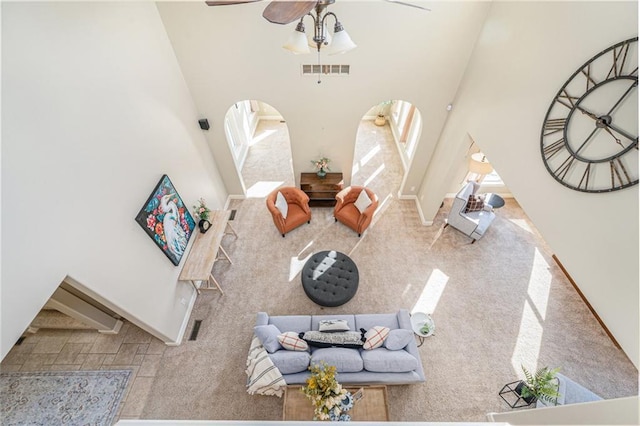 living room with ceiling fan and a high ceiling