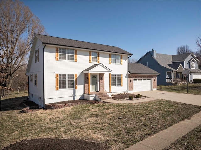 colonial house with an attached garage, concrete driveway, and a front lawn