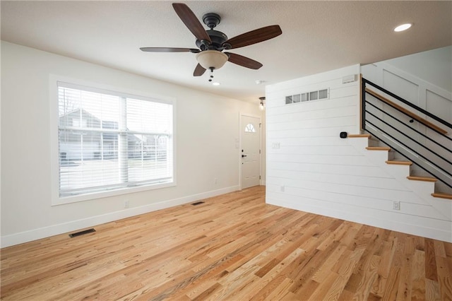 unfurnished living room with ceiling fan, visible vents, and light wood-type flooring