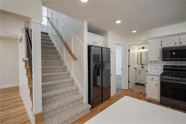 kitchen featuring light countertops, recessed lighting, stainless steel appliances, light wood-style floors, and white cabinetry