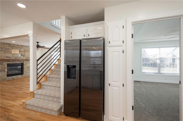 stairs with baseboards, recessed lighting, a fireplace, wood finished floors, and a ceiling fan