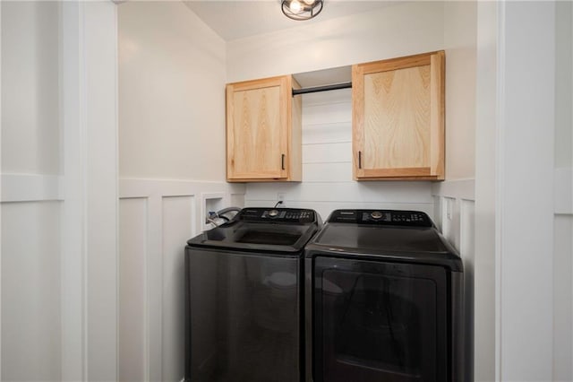 washroom with a decorative wall, a wainscoted wall, cabinet space, and independent washer and dryer