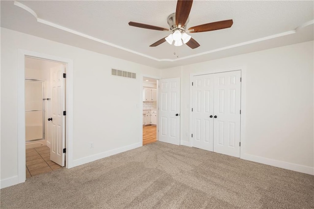 unfurnished bedroom with visible vents, ensuite bathroom, a closet, carpet floors, and baseboards