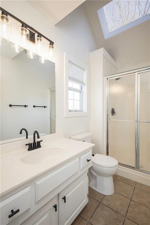 bathroom with tile patterned flooring, toilet, vanity, and a stall shower