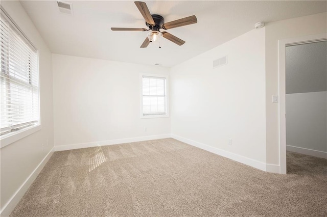 empty room with carpet flooring, a healthy amount of sunlight, and visible vents