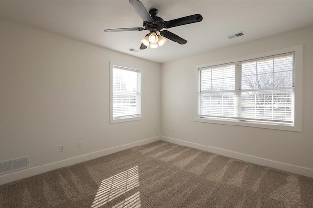 empty room featuring light colored carpet, visible vents, and baseboards