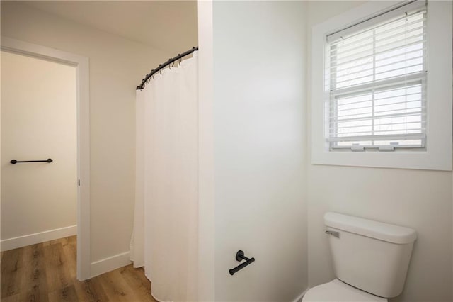 full bathroom featuring toilet, baseboards, and wood finished floors