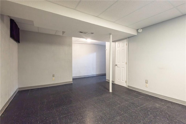 finished below grade area featuring a paneled ceiling and baseboards