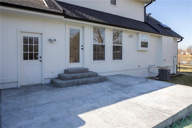 rear view of property featuring a patio area, central air condition unit, entry steps, and a shingled roof