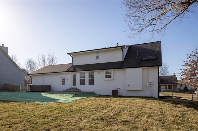 back of house with a lawn, cooling unit, a hot tub, and fence