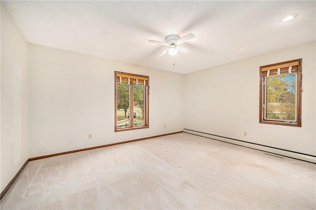 empty room featuring a baseboard radiator, light colored carpet, a textured ceiling, and ceiling fan