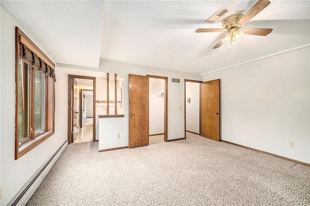 unfurnished bedroom with ceiling fan, a textured ceiling, carpet, and a baseboard heating unit