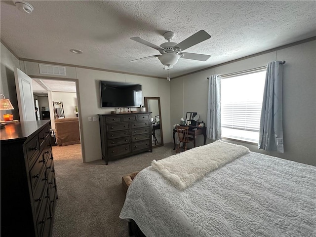 bedroom featuring crown molding, carpet flooring, visible vents, and a textured ceiling