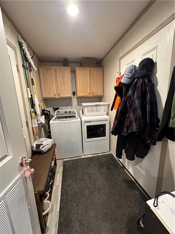 laundry room with wood finished floors, cabinet space, and washer and clothes dryer