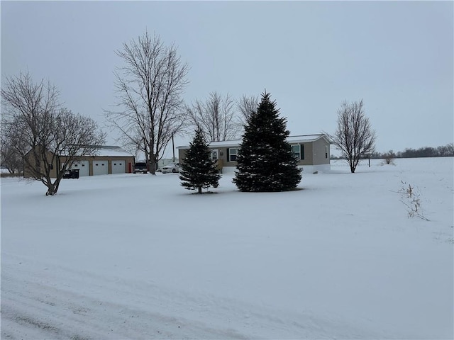 snowy yard featuring a garage