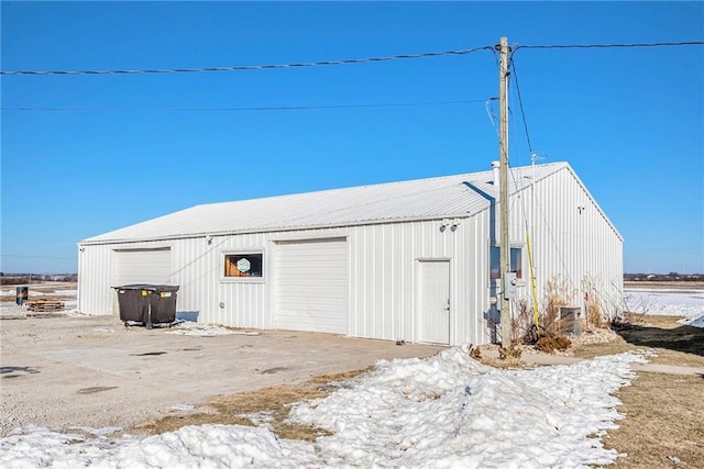 snow covered structure with a garage