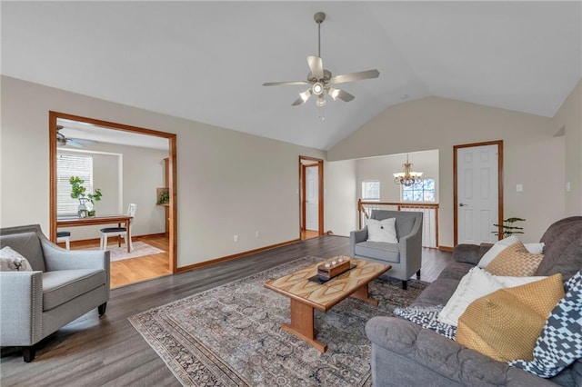 living room featuring dark wood-style floors, ceiling fan with notable chandelier, lofted ceiling, and baseboards