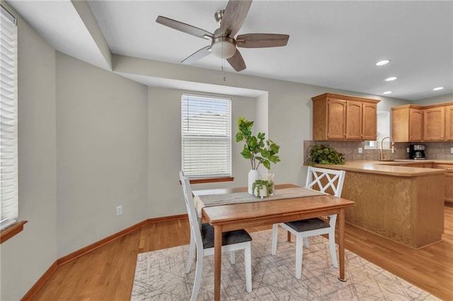 dining room with a ceiling fan, recessed lighting, baseboards, and light wood finished floors