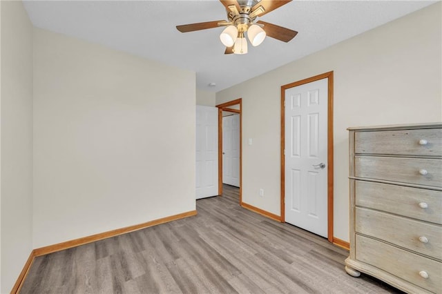 unfurnished bedroom featuring a ceiling fan, baseboards, and light wood finished floors