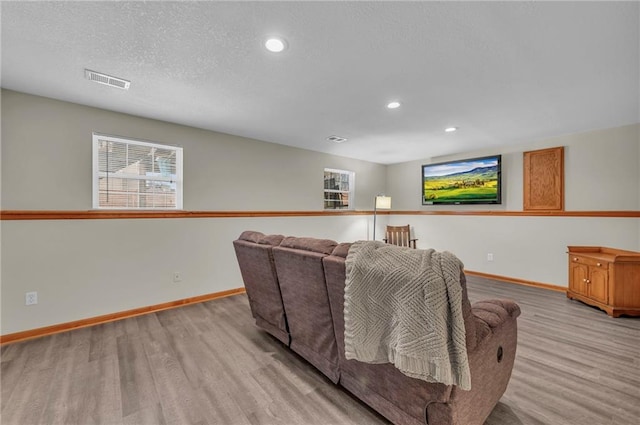 home theater room featuring light wood-style flooring, visible vents, and baseboards