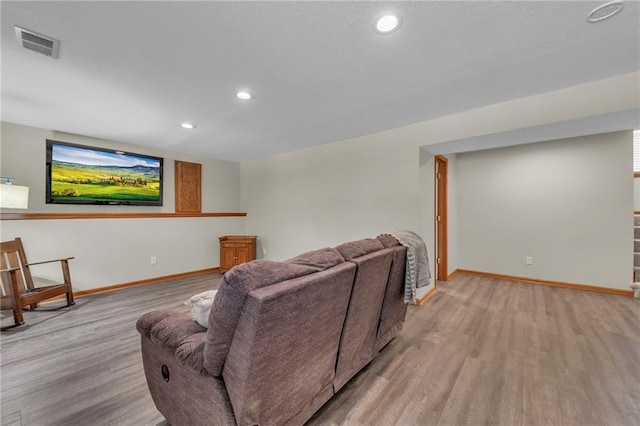 living room with light wood-style floors, recessed lighting, visible vents, and baseboards