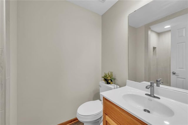 bathroom with vanity, toilet, and baseboards