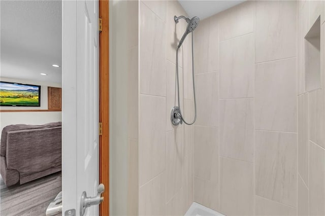 full bathroom featuring a tile shower and recessed lighting