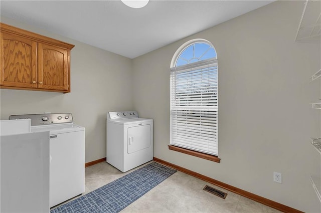 laundry room with cabinet space, baseboards, visible vents, and washer and dryer