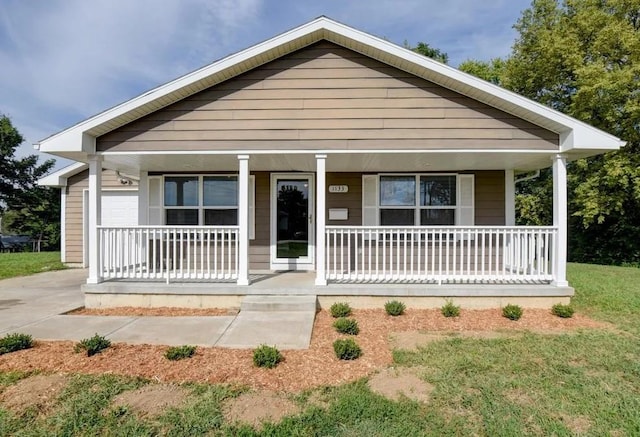 bungalow-style house featuring covered porch and a front lawn