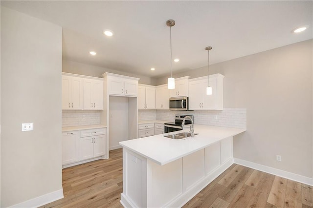 kitchen featuring sink, light hardwood / wood-style flooring, pendant lighting, stainless steel appliances, and white cabinets