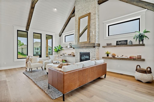 living room with light hardwood / wood-style flooring, beam ceiling, a fireplace, and high vaulted ceiling