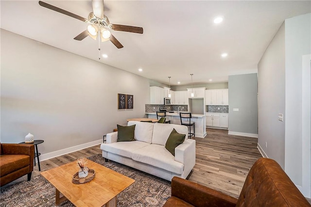 living room with hardwood / wood-style floors and ceiling fan