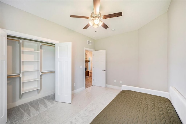 unfurnished bedroom with ceiling fan, radiator heating unit, carpet floors, and a closet