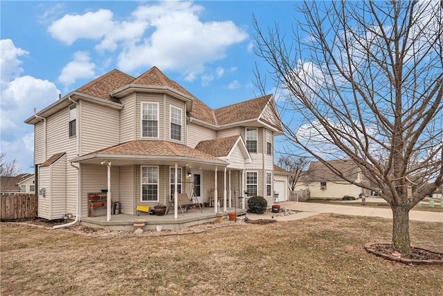 view of front of house featuring a garage, covered porch, and a front yard