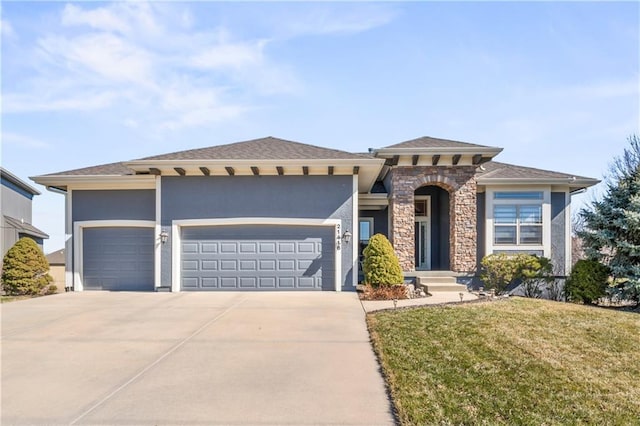 prairie-style home with a garage, concrete driveway, stone siding, stucco siding, and a front yard