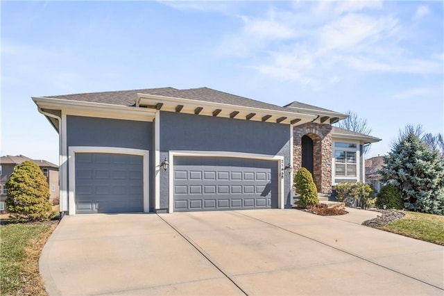 view of front facade featuring an attached garage, stone siding, concrete driveway, and stucco siding