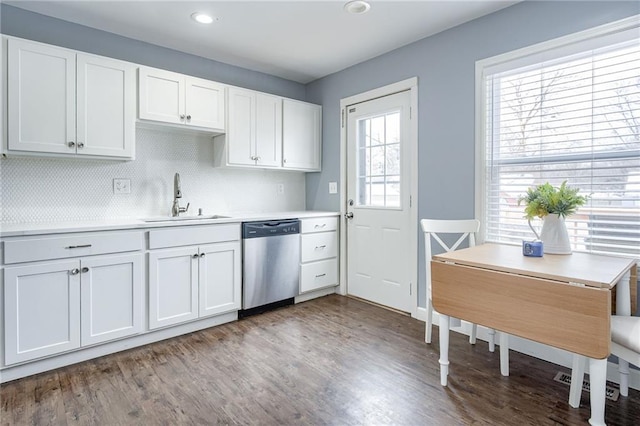 kitchen with light wood finished floors, light countertops, stainless steel dishwasher, white cabinets, and a sink