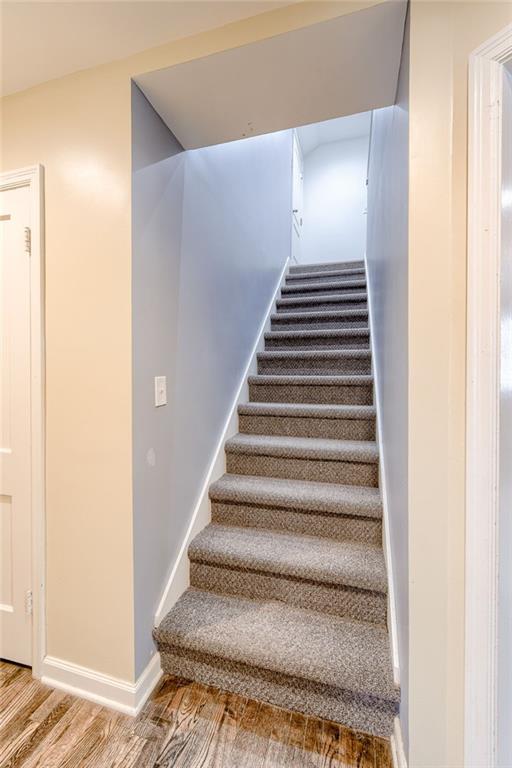 stairs with baseboards and wood finished floors