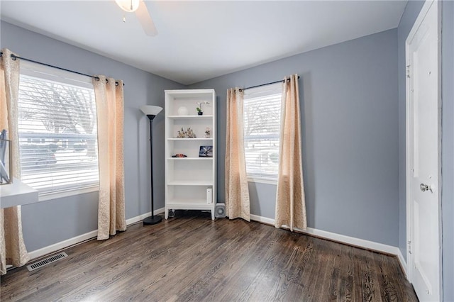 unfurnished bedroom with dark wood-style floors, ceiling fan, visible vents, and baseboards